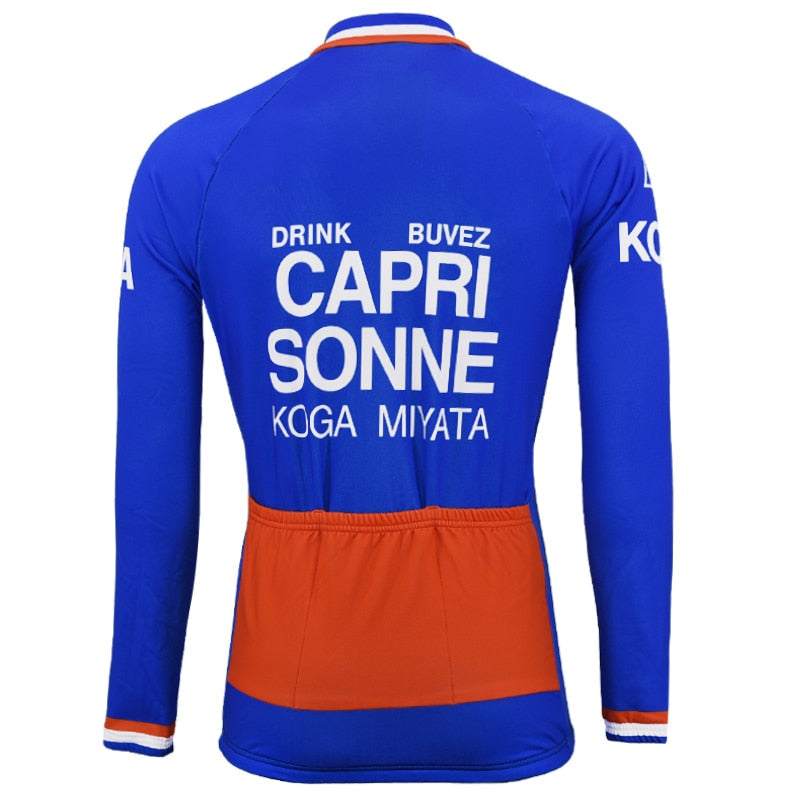 Introducing the Capri Sonne Retro Cycling Jersey Long Set with a vibrant blue and orange-accented design. Drink Capri Sonne Buvez is elegantly printed in white on the back, with two orange stripes at the bottom. A sleek gel seat pad ensures comfort for your ride.