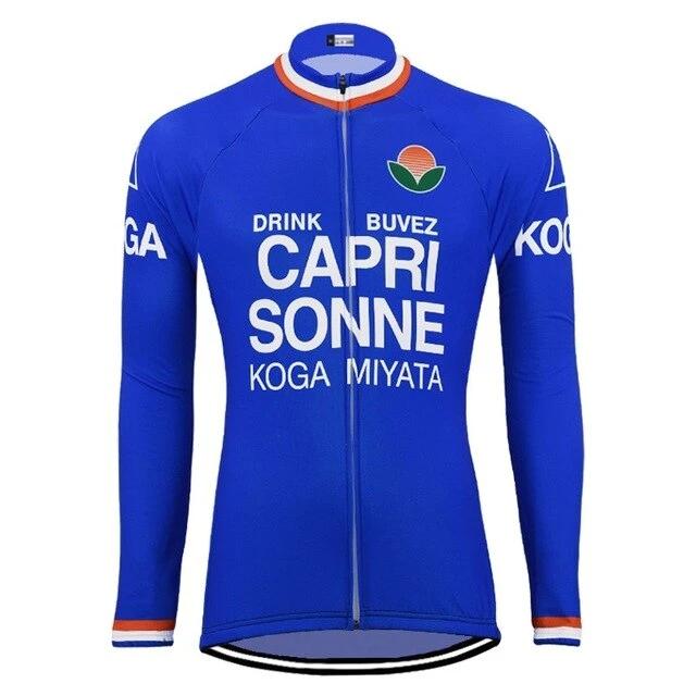 The Capri Sonne Retro Cycling Jersey Long Set showcases a blue design, DRINK BUVEZ CAPRI SONNE and KOGA MIYATA in white, an orange sun emblem with green leaves on the chest, and has a front zip. Available in fleece for cooler rides.
