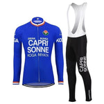 The Capri Sonne Retro Cycling Jersey Long Set includes a blue and black jersey with sponsor logos, matching black bib tights featuring white CAPRI SONNE text, and a gel seat pad for extra comfort. Available in fleece.