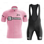 The Salvarani 1972 Retro Cycling Jersey Set, featuring a pink jersey with bold white Salvarani lettering and black bib shorts, embodies Grand Tour spirit. Sponsor logos on the sleeves and legs capture Felice Gimondis legendary style.