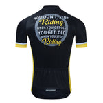 The back view of the Dont Stop Riding Cycling Jersey Set shows a black jersey with yellow accents, made from lightweight polyester. It reads, You dont stop riding when you get old, you get old when you stop riding. Features include breathable textured fabric and lower back pockets.
