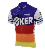 The Eddy Merckx Joker Emerxil Team 1986 Retro Cycling Jersey features a vibrant purple, blue, red, and orange gradient design with JOKER in bold white letters, a jester face, and sponsor logos. The short sleeves have white and blue stripes reflecting the Joker Emerxil Team style.