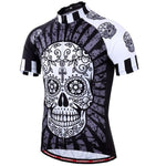 The Floral Black & White Skull Cycling Jersey features a large, detailed sugar skull design on the front, accented in black, white, and gray. Made from lightweight polyester with sleeves featuring smaller skull patterns and a front zipper for breathability.