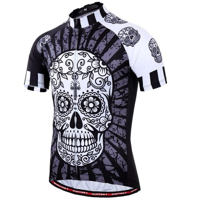 The Floral Black & White Skull Cycling Jersey features a large, detailed sugar skull design on the front, accented in black, white, and gray. Made from lightweight polyester with sleeves featuring smaller skull patterns and a front zipper for breathability.