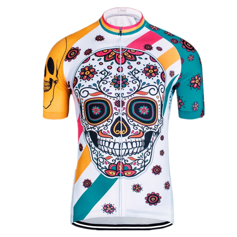 The Happy Skull Cycling Jersey features a vivid sugar skull design with floral patterns. Made from lightweight polyester, it showcases bright orange and teal stripes and a prominent skull motif on the left shoulder, all set against a predominantly white background.