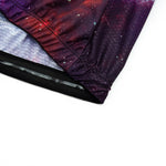Close-up of a fabric edge from a Womens Tacos Cat Cycling Jersey Set, featuring a galaxy print in red and purple tones. The fabric has gathered seams for texture, with a mesh-like lining inside.