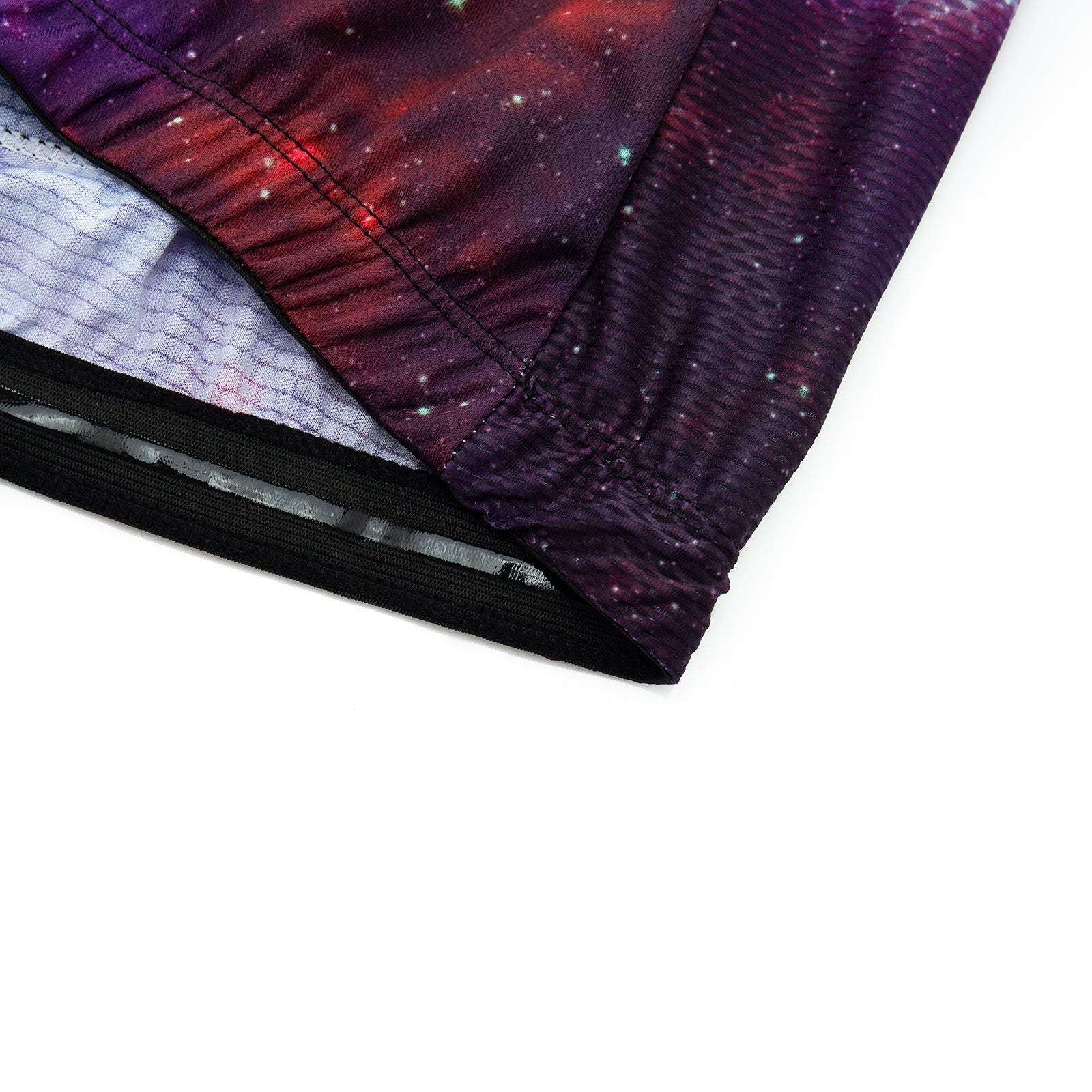 Close-up of a fabric edge from a Womens Tacos Cat Cycling Jersey Set, featuring a galaxy print in red and purple tones. The fabric has gathered seams for texture, with a mesh-like lining inside.
