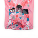 The Womens Pink Floral Cycling Jersey Set, featuring charming bicycle patterns and three back pockets, holds a WELIUI water bottle, two SiS energy bars, and a smartphone with a dark screen.