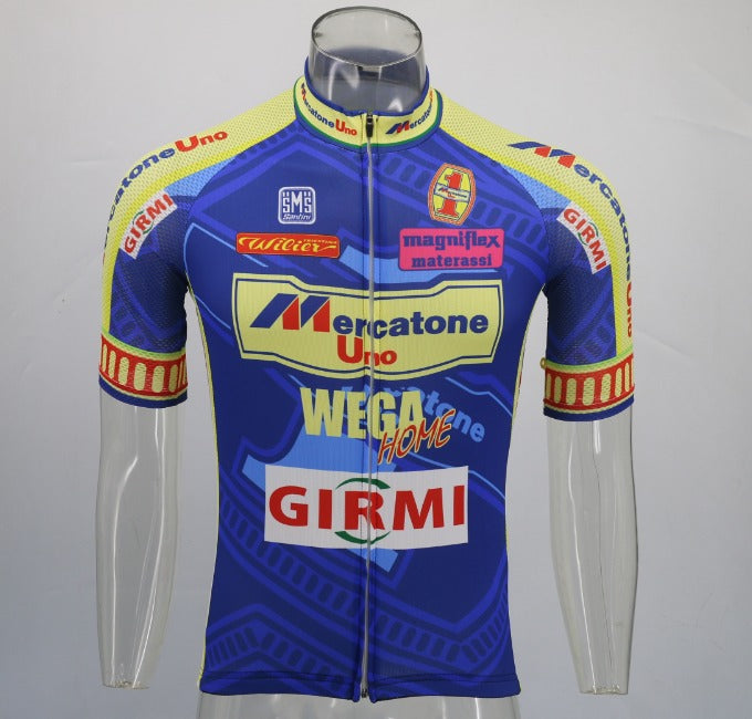 The Mercatone Uno Wega Retro Cycling Jersey on a mannequin features sponsor logos and is inspired by Marco Pantani, showcasing blue and yellow hues with red-accented sleeves and a zip front closure.