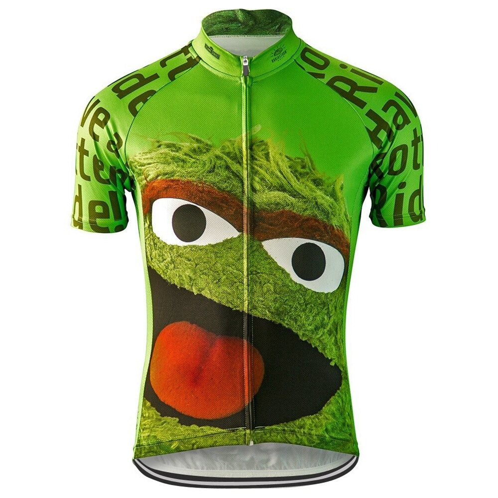 The Oscar the Grouch Sesami Street Retro Cycling Jersey in green features a large cartoon face inspired by Oscar the Grouch, including bushy eyebrows and a wide-open mouth. The jersey has text on the sleeves and sides and comes with a full front zipper.