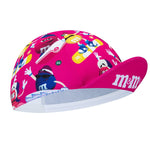 The M&Ms Retro Cycling Cap is a vibrant pink cap with colorful M&Ms characters in various poses printed across it, featuring a vintage style and prominently displaying the M&Ms logo on the brim.