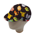 The medium-sized Pokemon Cycling Cap, displayed on a mannequin head, sports a retro design with colorful cartoon characters, featuring a yellow mouse, blue turtle, and small orange dragon playfully posed on a black background.