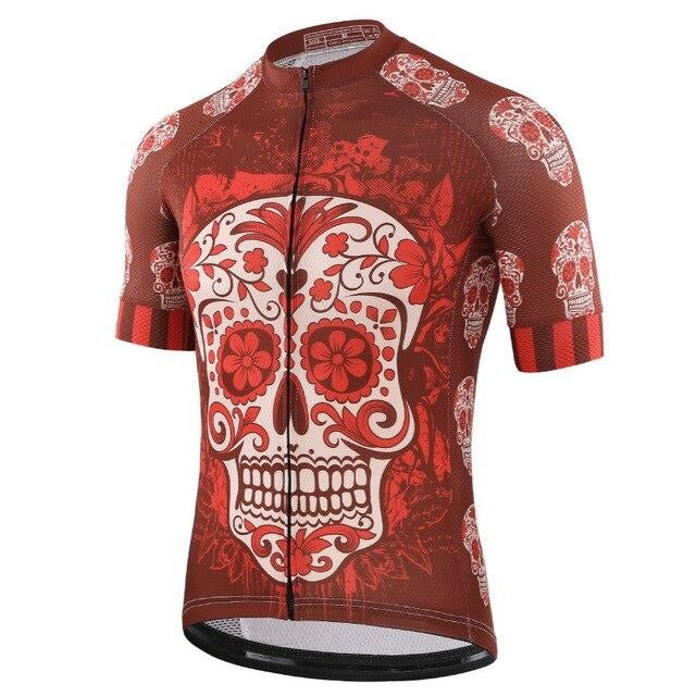 The Red Skull Cycling Jersey is a lightweight polyester jersey featuring a striking red and white sugar skull design on the front, set against a rich brown background with smaller skulls and floral motifs. It includes a full-length front zipper for easy wear.
