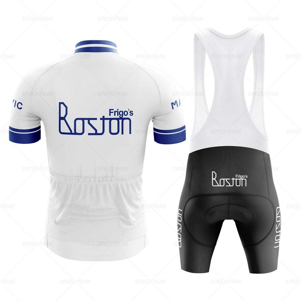 The Frigos Boston Retro Cycling Jersey Set includes a white and blue jersey with the Frigos Boston logo, featuring a blue collar and cuffs for comfort. It comes with matching black bib shorts displaying the same logo on the side.