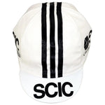 This retro cycling cap, named SCIC Cucine Conponibili, showcases three vertical black stripes and bold logos on the front and sides. Add classic style to your ride by purchasing it at vintagecycling.shop.