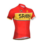 The Spanish España Retro Cycling Jersey is a lightweight red polyester jersey with a yellow stripe and SPAIN in bold black letters. It features breathable mesh panels on the sleeves and sides, along with a small logo and crown emblem for added flair.
