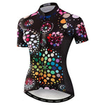 The Womens Coloured Dots Cycling Jersey features a lightweight polyester fabric with a black base adorned by vibrant multicolored geometric dot patterns of various sizes across the entire jersey.