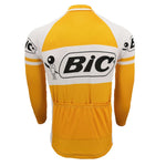 The BIC Yellow Long Sleeve Retro Cycling Jersey, available in a fleece option, features a white and orange design with the Bic logo and figure on the back and sleeves. Made from lightweight polyester, it includes pockets on the lower back for a sporty look.