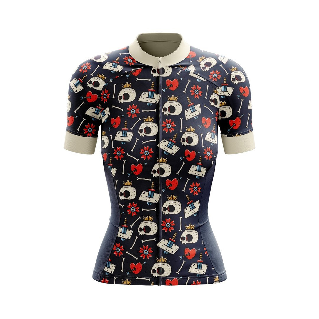 The Womens Temple Skull Cycling Jersey features a whimsical skull pattern with hearts, stars, and crowns on a dark background. It includes short sleeves, a light-colored collar, and sleeve cuffs designed for performance on any cycling adventure.