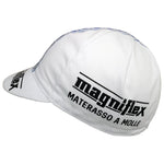 The white Magniflex Retro Cycling Cap features the logo and text magniflex MATERASSO A MOLLE in black. It boasts a small, curved brim and visible stitching for a classic retro look when viewed from the side.