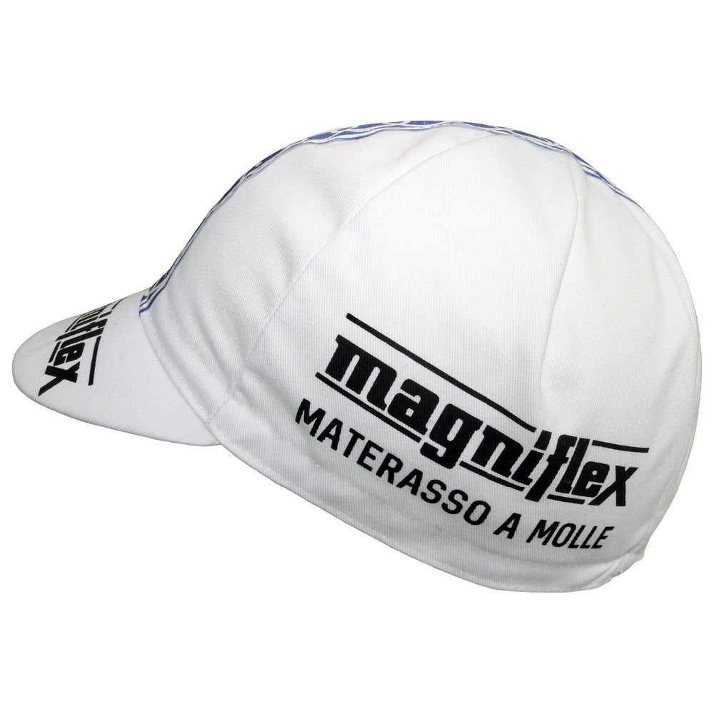 The white Magniflex Retro Cycling Cap features the logo and text magniflex MATERASSO A MOLLE in black. It boasts a small, curved brim and visible stitching for a classic retro look when viewed from the side.