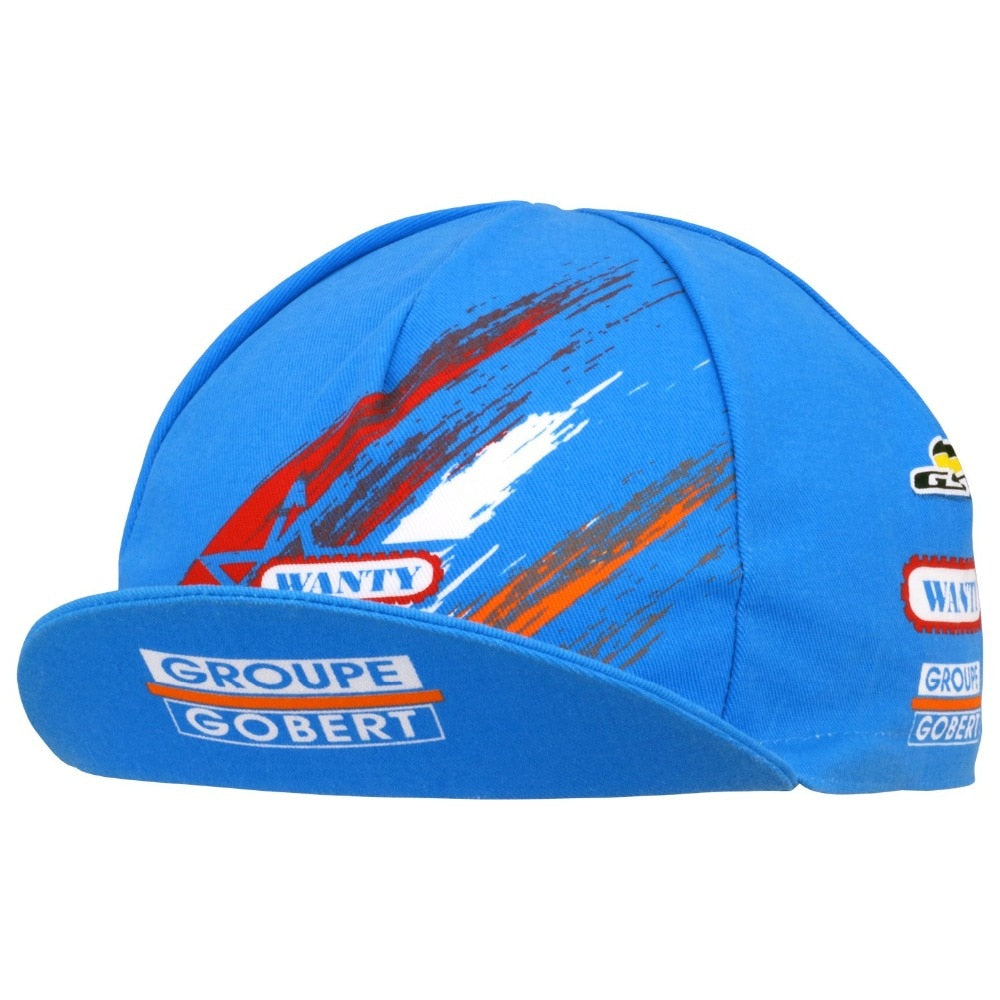 Cycling enthusiasts will love the blue Groupe Gobert Retro Cycling Cap, featuring a colorful abstract design with red, orange, and white streaks. The brim displays GROUPE GOBERT in bold letters, while the iconic WANTY logo adds a classic touch.