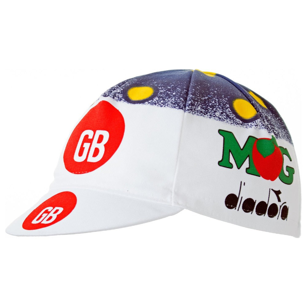 The GB-MG Maglificio Retro Cycling Cap has a short brim, red and white GB logos, yellow circles, and a blue area resembling the night sky. The side displays a MOG logo with a red heart and classic diadora branding, capturing the timeless essence of GB-MG Maglificio.