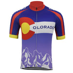 Introducing the Colorado Retro Cycling Jersey, featuring the states iconic flag design with a vintage C logo, red circle, and yellow center. The sleeves display a red and blue pattern, complemented by stylized white mountain peaks on the purple bottom.