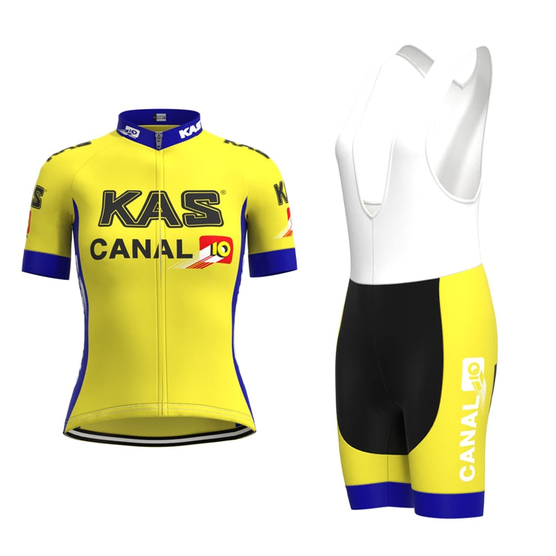 The Womens KAS Canal Retro Cycling Jersey Set features a vintage yellow and white design with KAS and CANAL 10 logos, including a short-sleeve jersey with blue accents and bib shorts in yellow, black, and white, exuding classic cycling charm.