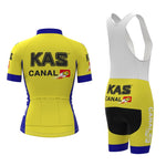 The Womens KAS Canal Retro Cycling Jersey Set includes a yellow jersey with black KAS CANAL 10 text, short sleeves, and a front zipper. The bib shorts feature a white top with straps and black padded shorts, all adorned with matching branding.