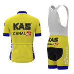 Explore the KAS Canal Retro Cycling Jersey Set featuring a yellow and white jersey with vintage logos and breathable fabric, paired with bib shorts accented in blue and white, complete with a zip front, short sleeves, and black padding for comfort.