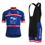 A US Postal Service Short Sleeve Pro Cycling Team Jersey Set in blue and red, featuring sponsor branding and logos from Lance Armstrongs era, along with matching black and blue bib shorts, is displayed.