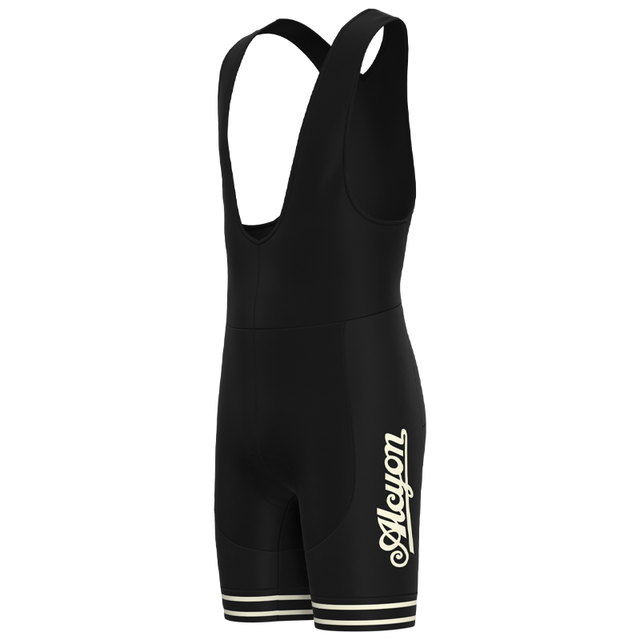 The Paris-Roubaix Retro Cycling Jersey Set includes black bib shorts with a sleeveless design, crisscross back straps, bold Auyon on the leg, contrasting white stripes on cuffs, and a breathable gel seat pad for cycling comfort.