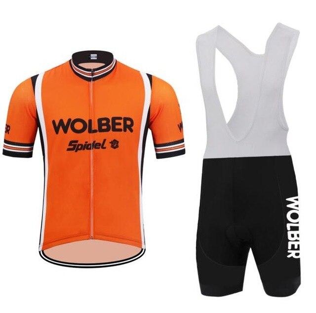 Wolber Spidel Retro Cycling Jersey Set: Orange short-sleeve jersey with a front zipper and WOLBER Spiele text, made from lightweight polyester, paired with black bib shorts featuring white straps and WOLBER on the thigh.