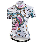 Womens Snake & Skull Cycling Jersey: This eye-catching garment features an edgy design with skulls, flowers, and bold phrases like REAL LIFE and TIME, set against a white background with black, pink, blue, and orange details.