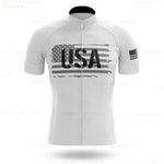 The USA White Cycling Team Jersey is a short-sleeve performance jersey made from lightweight polyester, showcasing a large distressed American flag and USA text on the front, with another flag on the left sleeve. It features a convenient front zipper.