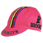 The Brooklyn Retro Cycling Cap is pink with Brooklyn in black, featuring green, yellow, blue, and red stripes down the center and a small bridge graphic near the text, echoing the charm of Brooklyn Chewing Gum.