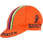 The Brooklyn Retro Cycling Cap in orange features a short brim, vibrant blue, green, yellow, and red stripes, with Brooklyn and a bridge logo in black, capturing the nostalgic charm of Brooklyn Chewing Gum.