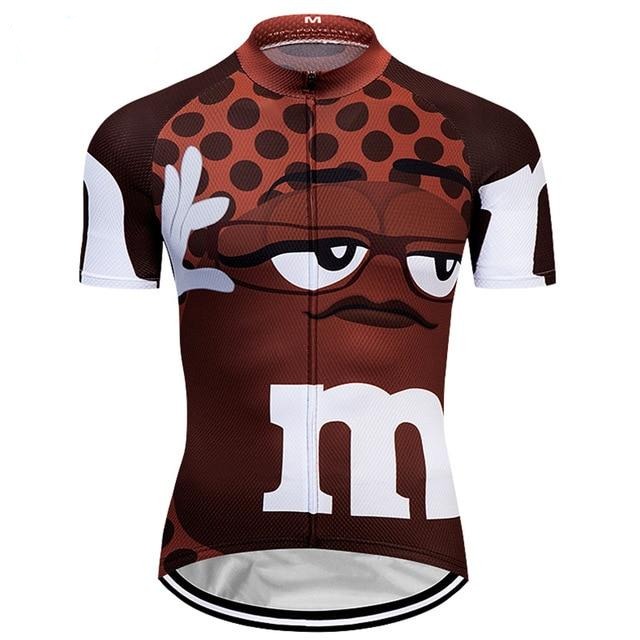 The M&Ms Brown Cycling Jersey is crafted from lightweight polyester and features a glasses-wearing brown candy character. It boasts white M logos on the sleeves and front, celebrating its M&Ms theme, while darker brown polka dots add an elegant touch.