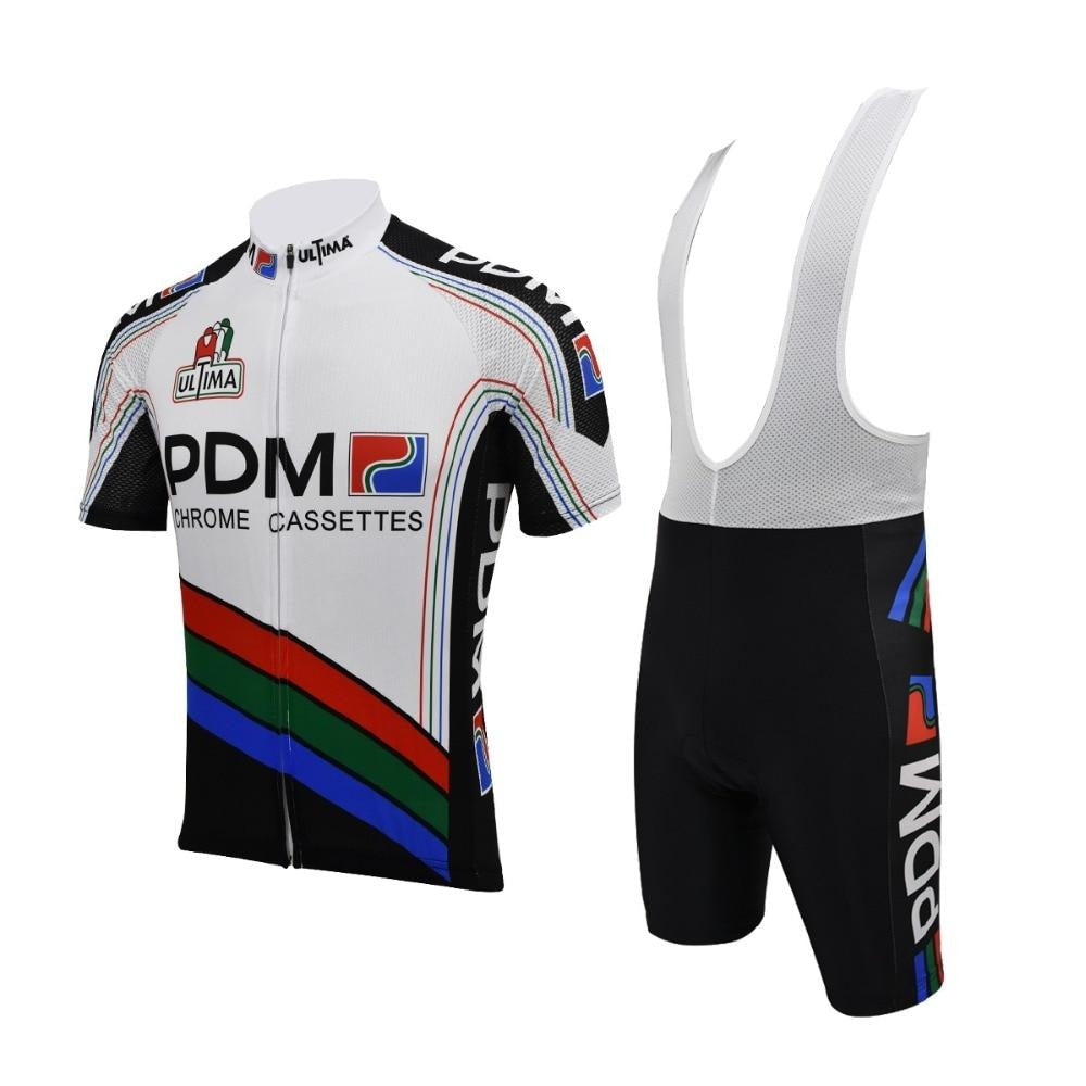 The Équipe Cycliste PDM (Chrome Cassettes) Retro Cycling Jersey Set includes a white short-sleeved jersey with black, red, blue, and green accents featuring PDM and Chrome Cassettes text, paired with black bib shorts that complement the vibrant design.