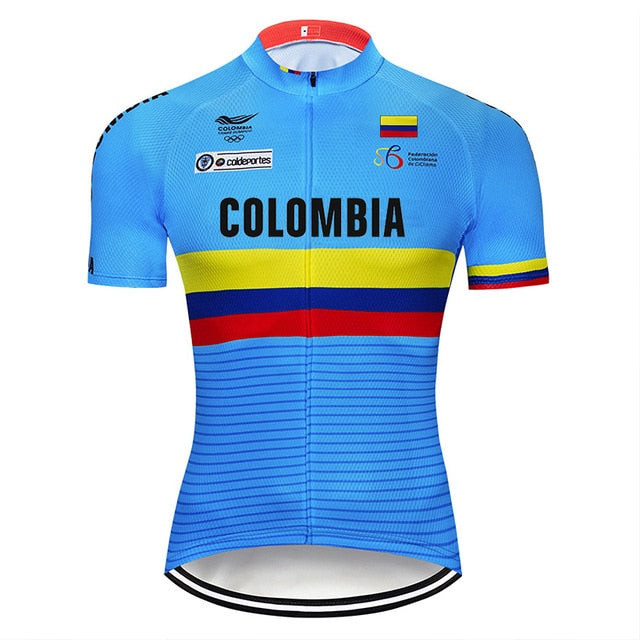 The image features the Colombia Team Cycling Jersey, crafted from lightweight polyester in blue. It prominently displays Colombia on the front with horizontal yellow, blue, and red stripes, plus official logos and the Colombian flag on the chest for authenticity.