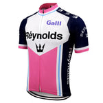 The Reynolds Galli 1981 Retro Cycling Jersey showcases a vibrant pink, white, and blue design with Reynolds on the front. Crafted from lightweight polyester, it features dark blue shoulders with white logos and includes a centered zipper and silicone waist strip for a snug fit.