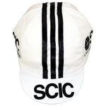 This retro cycling cap, named SCIC Cucine Conponibili, showcases three vertical black stripes and bold logos on the front and sides. Add classic style to your ride by purchasing it at vintagecycling.shop.