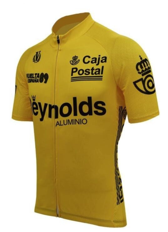 The Yellow Reynolds Aluminio Retro Cycling Jersey celebrates Pedro Delgados Vuelta a España 89 victory, featuring Caja Postal and Reynolds logos on vibrant yellow, a full front zipper, short sleeves, and black text with graphics on the chest and sides.