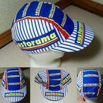 The Castorama Retro Cycling Cap features multicolored designs with blue and white vertical stripes and castorama in yellow on horizontal bands of blue and red, shown on a mannequin head displaying front, top, back, and side views.